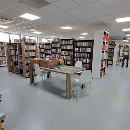 Winkelvloer met boeken in stellingen, leestafels en leeshoeken in een kringloopwinkel