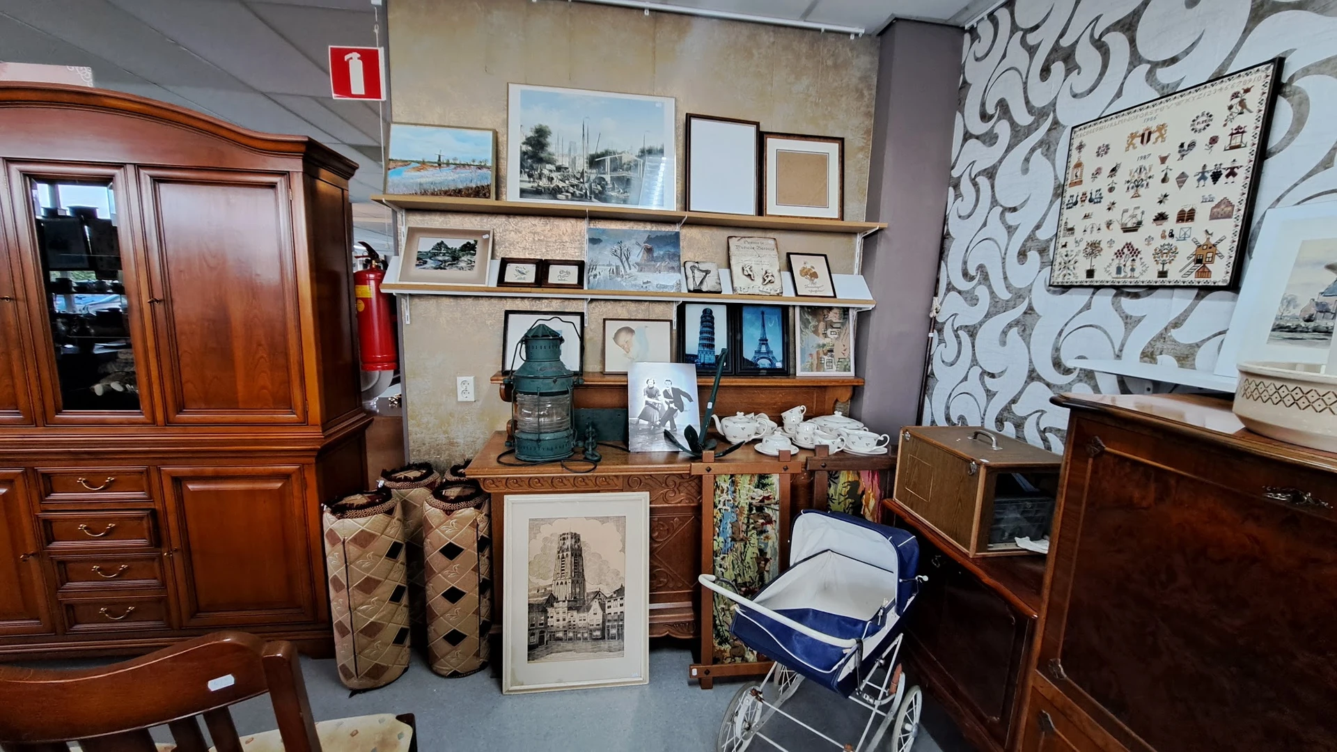 Winkelvloer met houten meubels, wanddecoratie, schilderijen en diverse tweedehands spullen