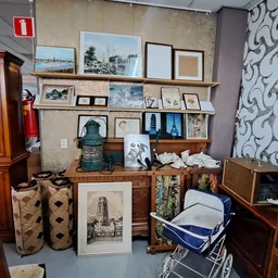 Winkelvloer met houten meubels, wanddecoratie, schilderijen en diverse tweedehands spullen