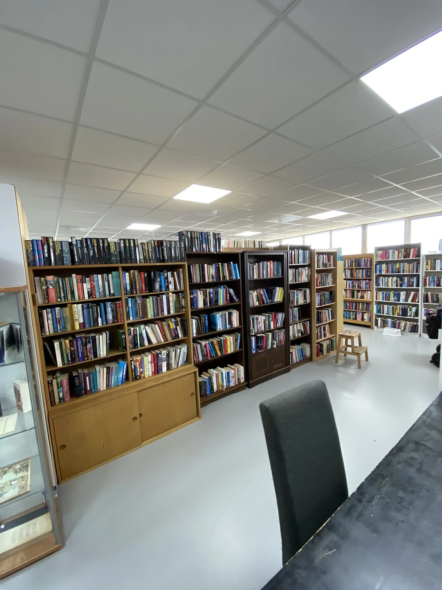 Binnenzicht van kringloopwinkel met meerdere boekenkastjes gevuld met dvd's en boeken