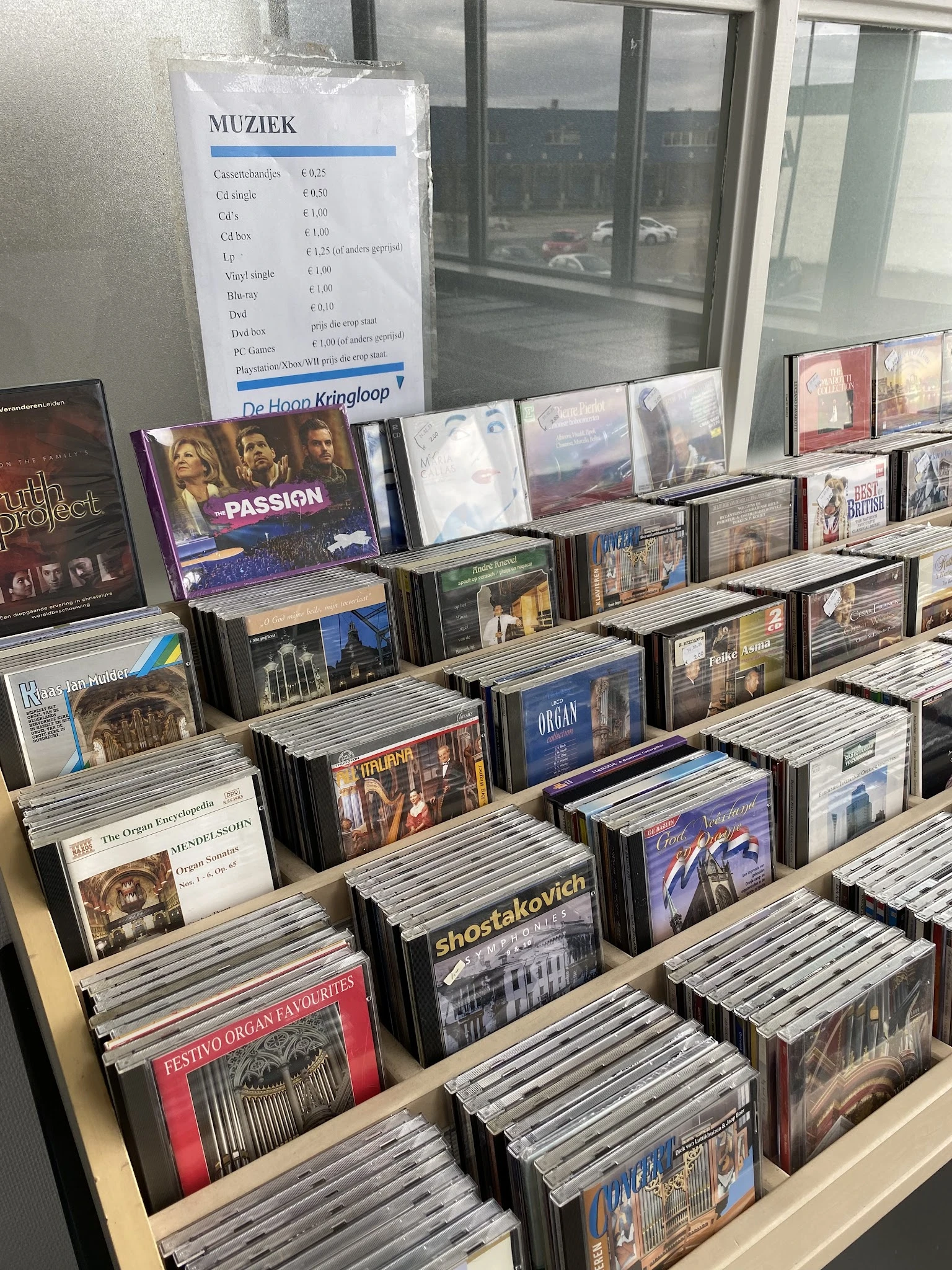 Uitgestalde cd's en dvd's op rekken, onder meer klassieke muziek en religieuze titels