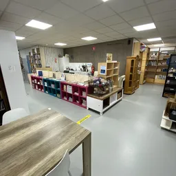 Winkelvloer met gekleurde stellingen, boekenkasten en verschillende afdelingen in een kringloopwinkel