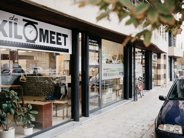 Winkelpui van kringloopwinkel met zwarte frame en grote ramen, winkelnaam duidelijk zichtbaar