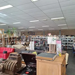 Overzicht van winkelvloer met meubels, fauteuils, stellingen met spullen en diverse artikelen