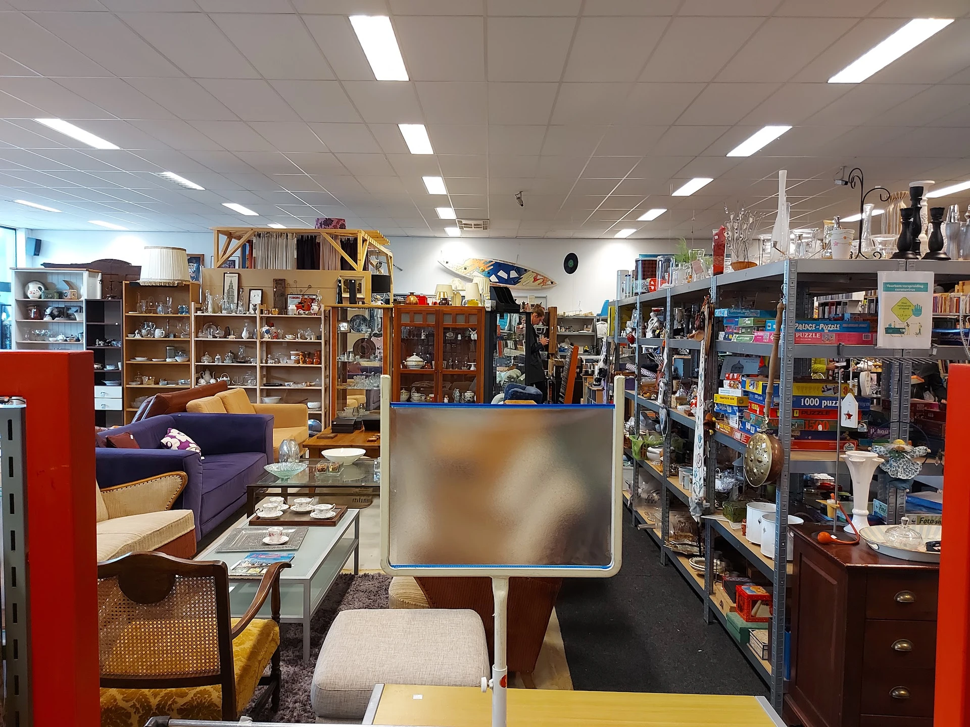 Winkelvloer met meubels, boekenrekken, vintage items en speelgoed in een kringloopwinkel