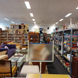 Winkelvloer met meubels, boekenrekken, vintage items en speelgoed in een kringloopwinkel