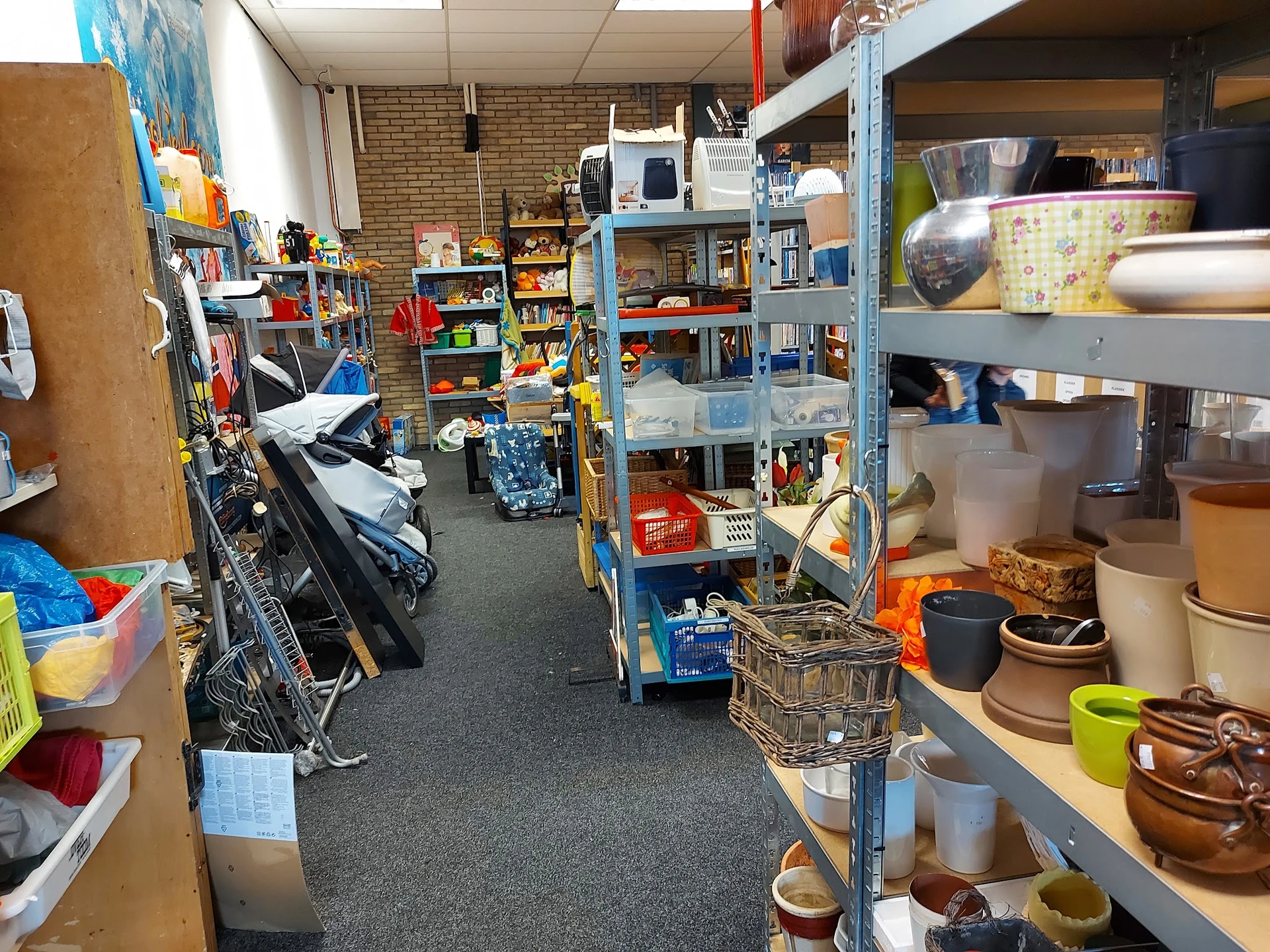 Winkelinterieur met blauwe stellingen vol huishoudelijke spullen, gebruiksvoorwerpen en diverse artikelen