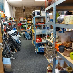 Winkelinterieur met blauwe stellingen vol huishoudelijke spullen, gebruiksvoorwerpen en diverse artikelen