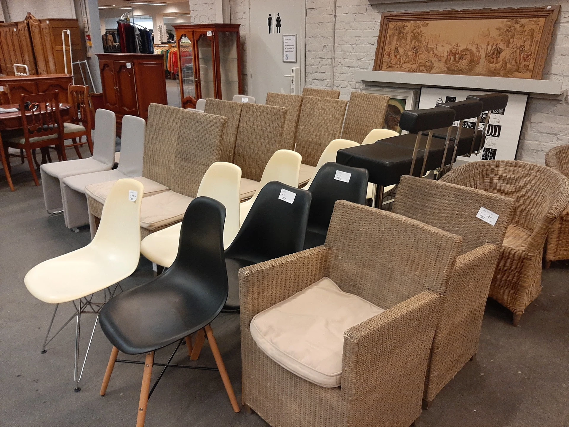 Diverse stoelen en fauteuils uitgestald in de winkel, waaronder design stoelen en textielmeubels