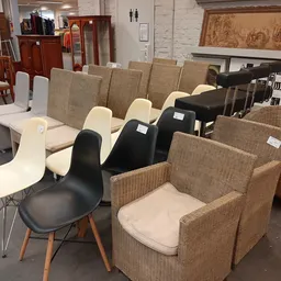 Diverse stoelen en fauteuils uitgestald in de winkel, waaronder design stoelen en textielmeubels