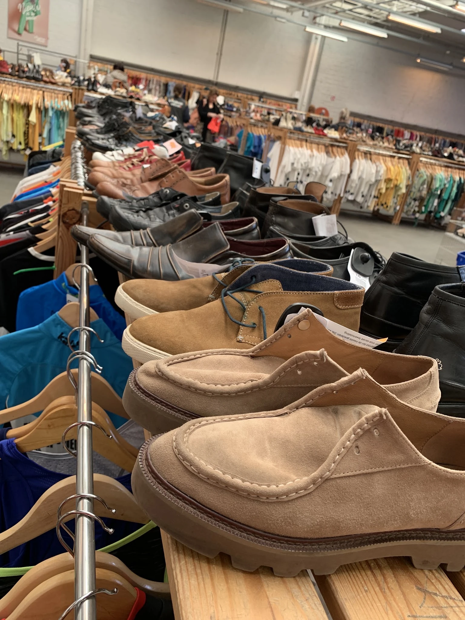 Rekken met tweedehands schoenen en laarzen in verschillende kleuren en stijlen
