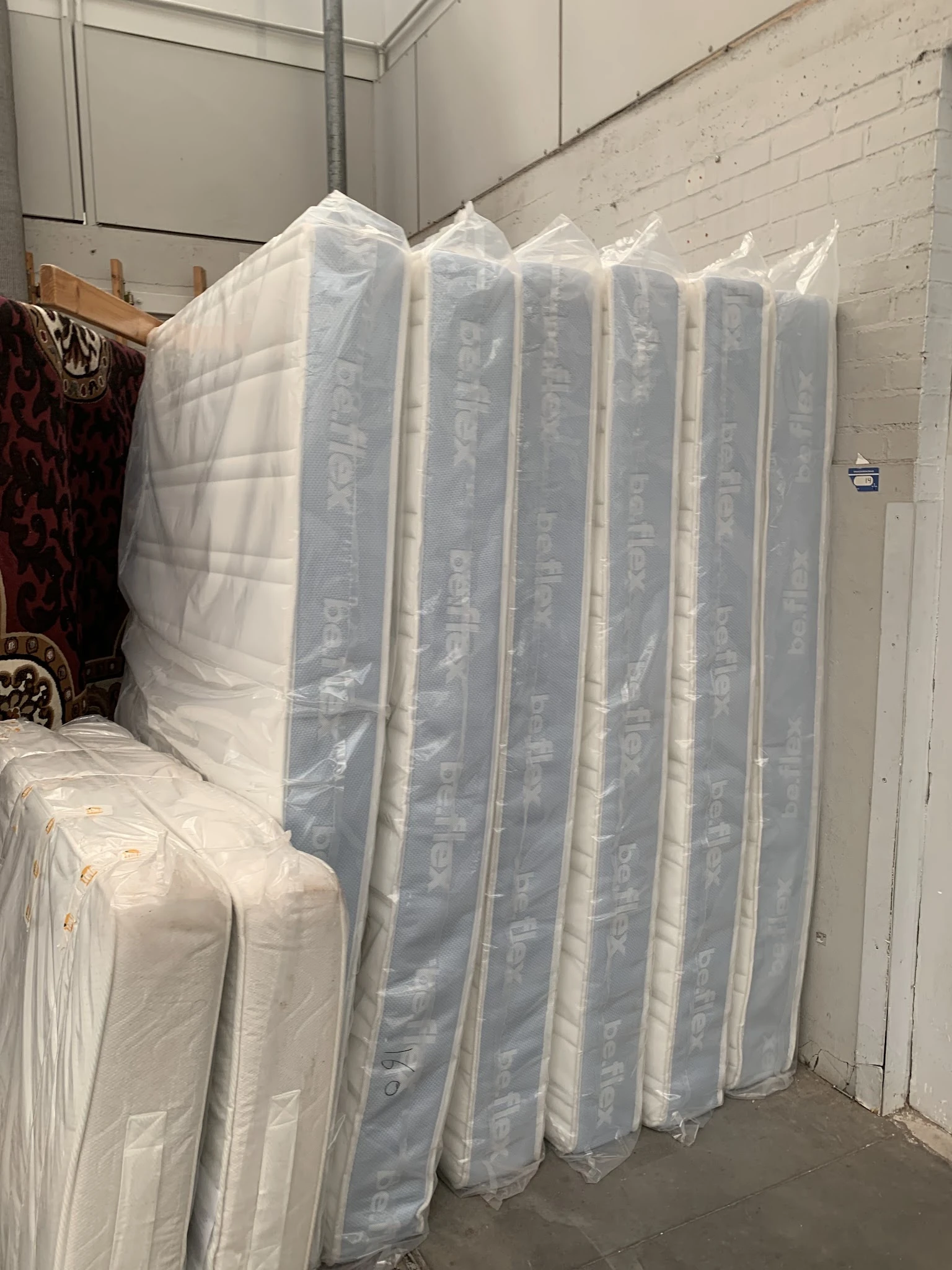 In plastic verpakte matrassen opgesteld in een opslagruimte