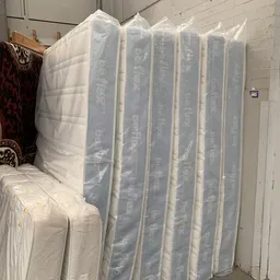 In plastic verpakte matrassen opgesteld in een opslagruimte