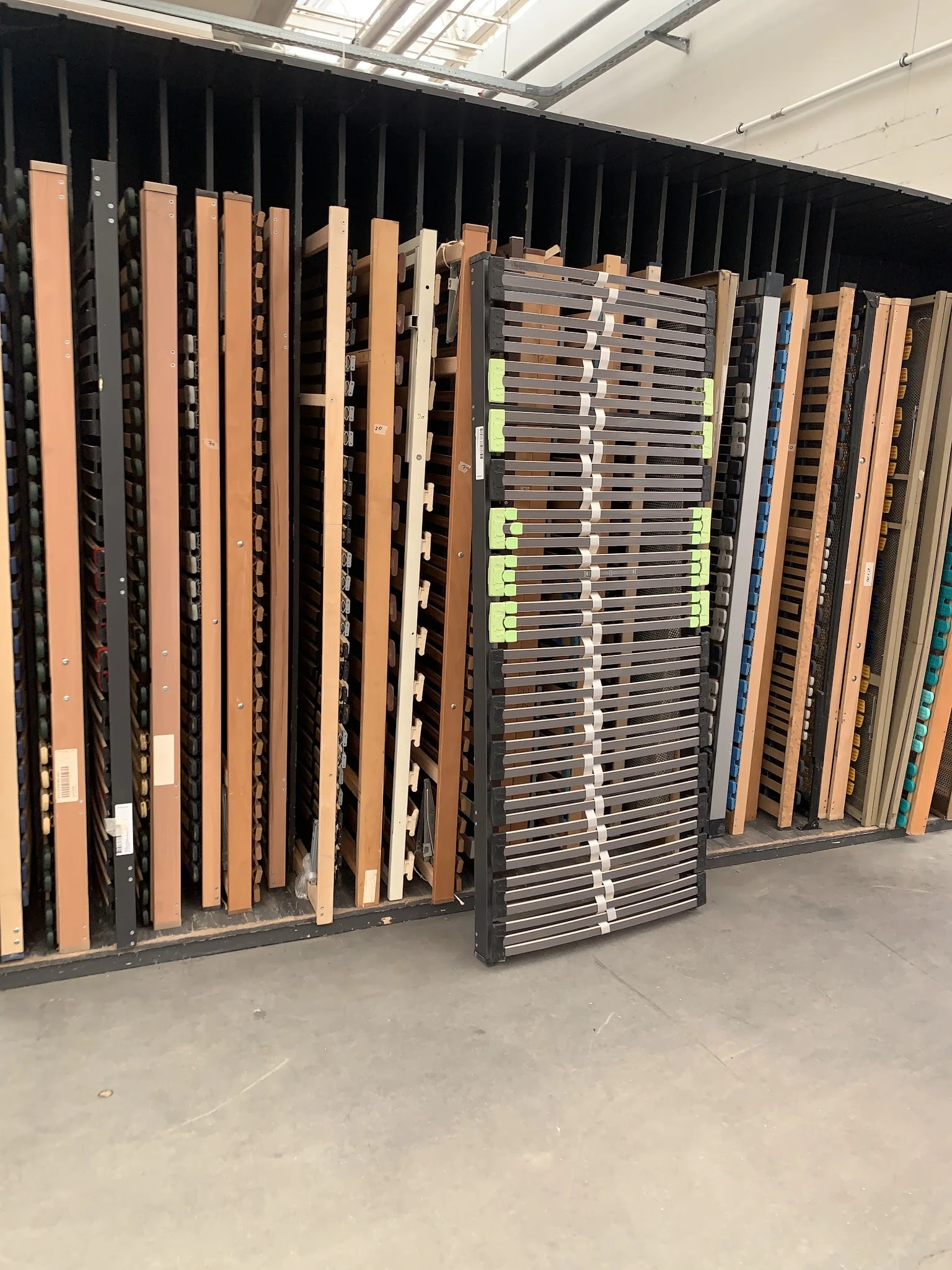 Verschillende bedframes en matrassen staande tegen elkaar in een opslagruimte