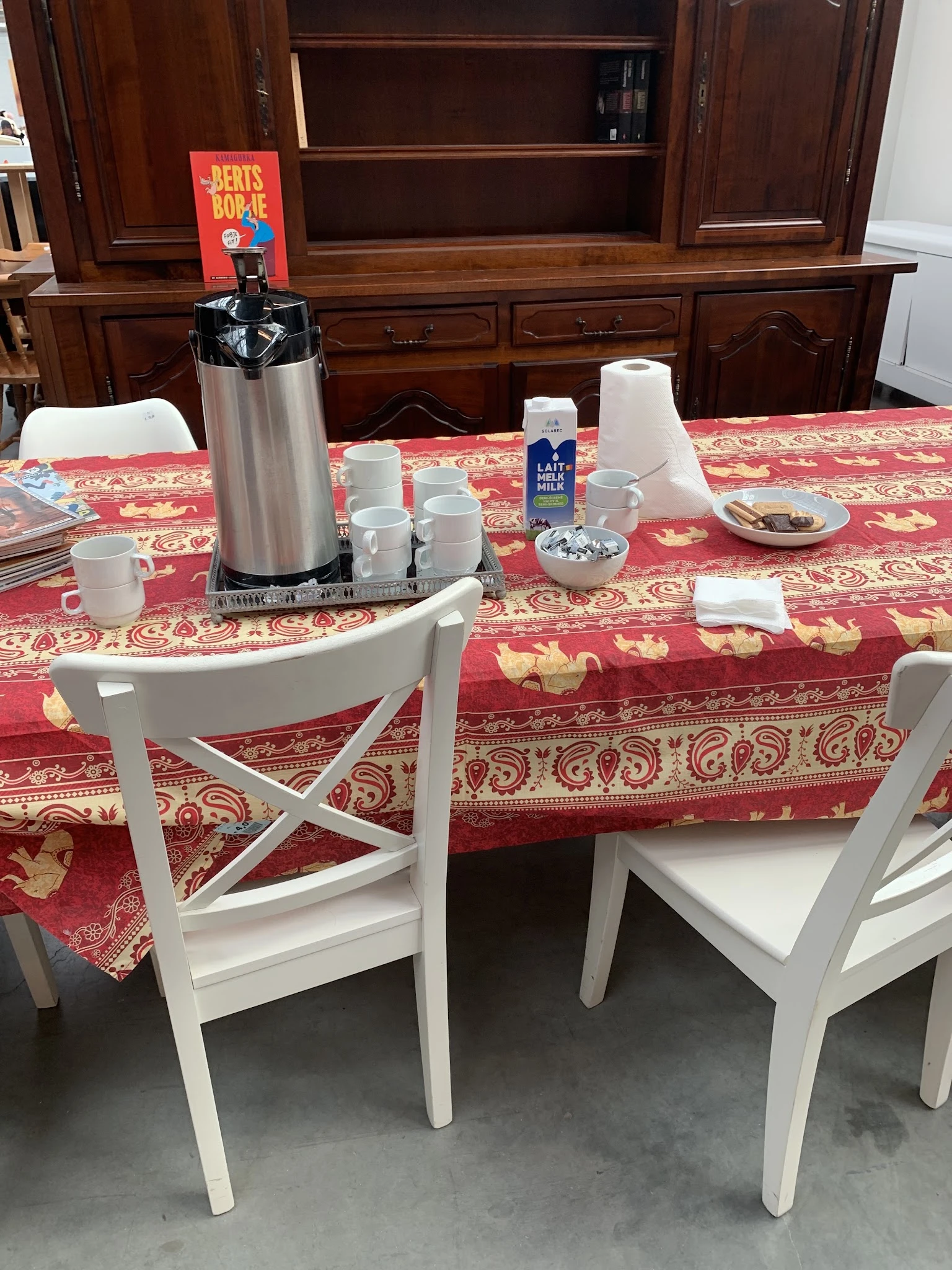 Eettafel met koffieapparaat, kopjes, melk en servetten voor koffiedrinken