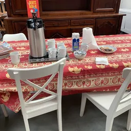 Eettafel met koffieapparaat, kopjes, melk en servetten voor koffiedrinken