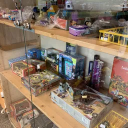 Vitrinekast met verzameling bordspellen, speelgoed en collectibles op houten stellage