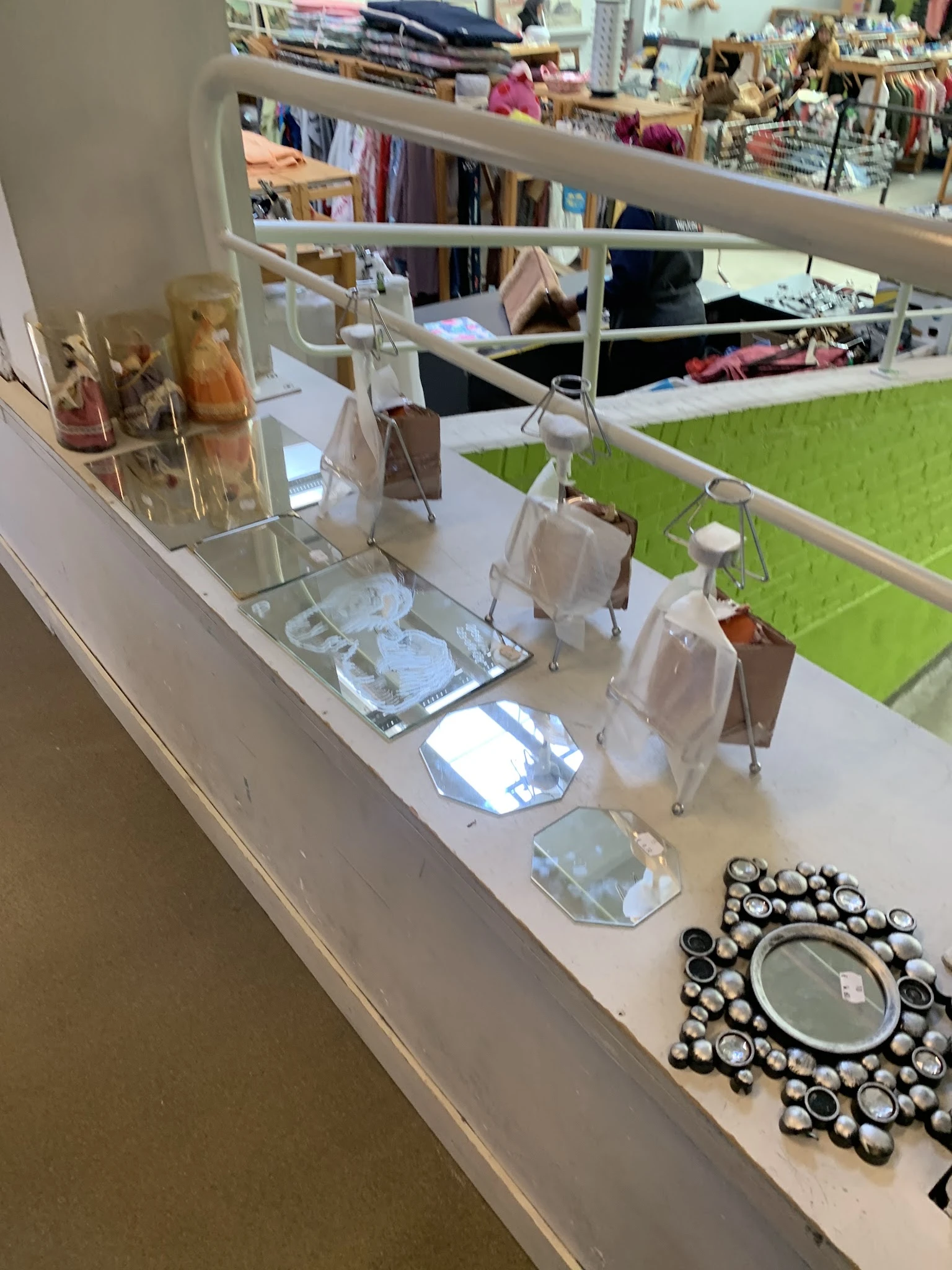 Uitstalling van diverse huishoudelijke items en serviesgoed op een witte winkelplank
