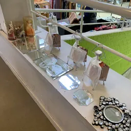Uitstalling van diverse huishoudelijke items en serviesgoed op een witte winkelplank