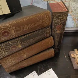 Stapel antieke boeken met leren inband en gouden decoratie, waaronder een Oosthoeks encyclopedie