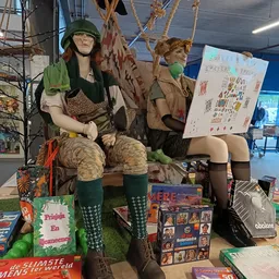 Etalage met poppen gekleed in vintage kleding en diverse tweedehands items zoals boeken en accessoires