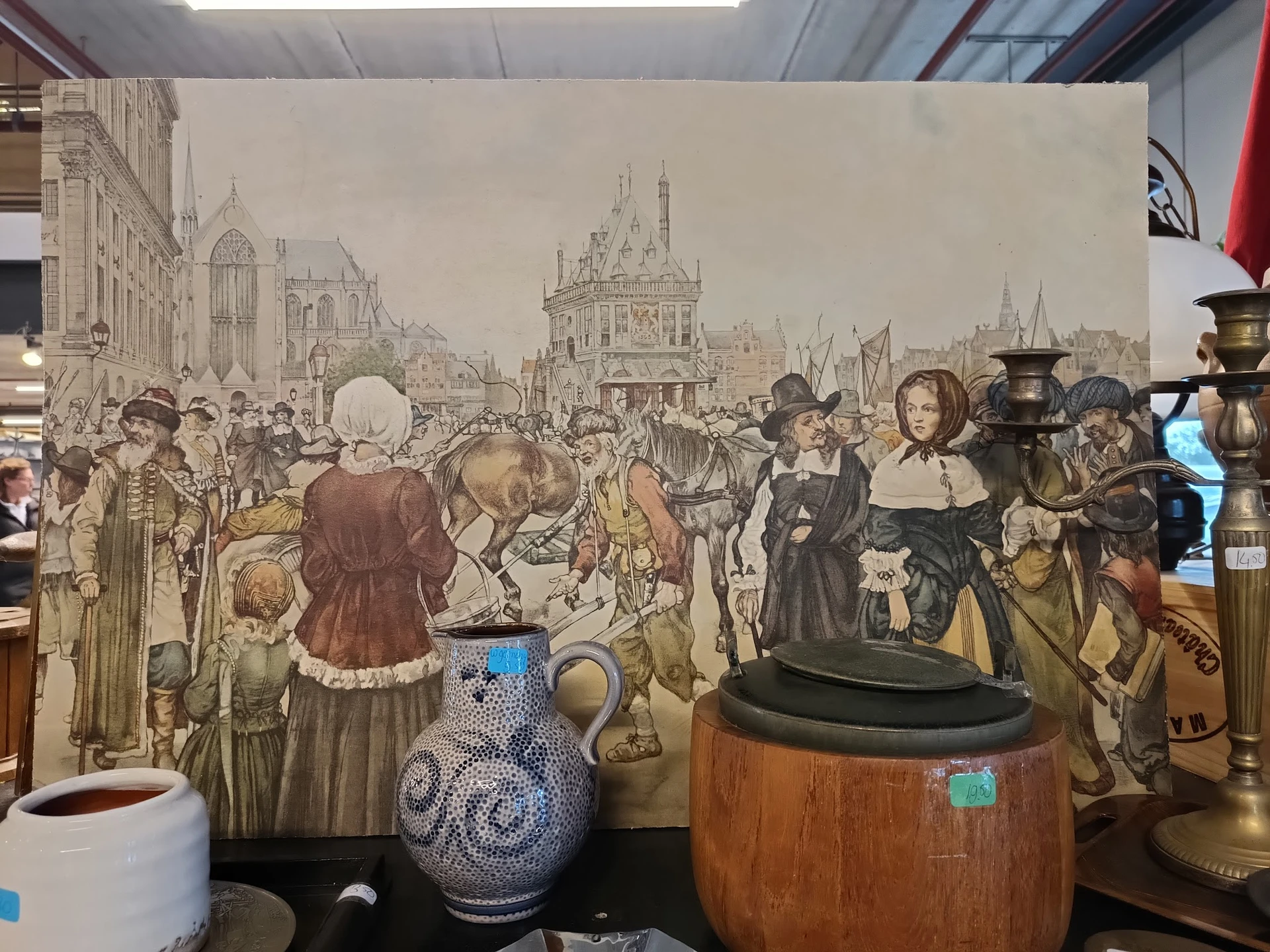 Uitgestalde antieke en vintage items waaronder aardewerk, kandelaars en decoratieve voorwerpen voor een historisch tafereel
