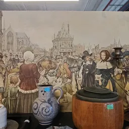 Uitgestalde antieke en vintage items waaronder aardewerk, kandelaars en decoratieve voorwerpen voor een historisch tafereel