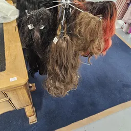 Bovenaanzicht van pruiken op een tafel in een winkelruimte