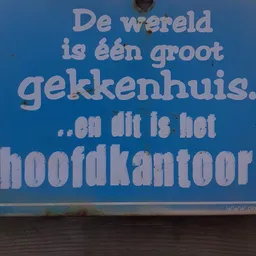 Blauwe bord met wit tekstbericht in Nederlands over een groot gekkenhuis en hoofdkantoor