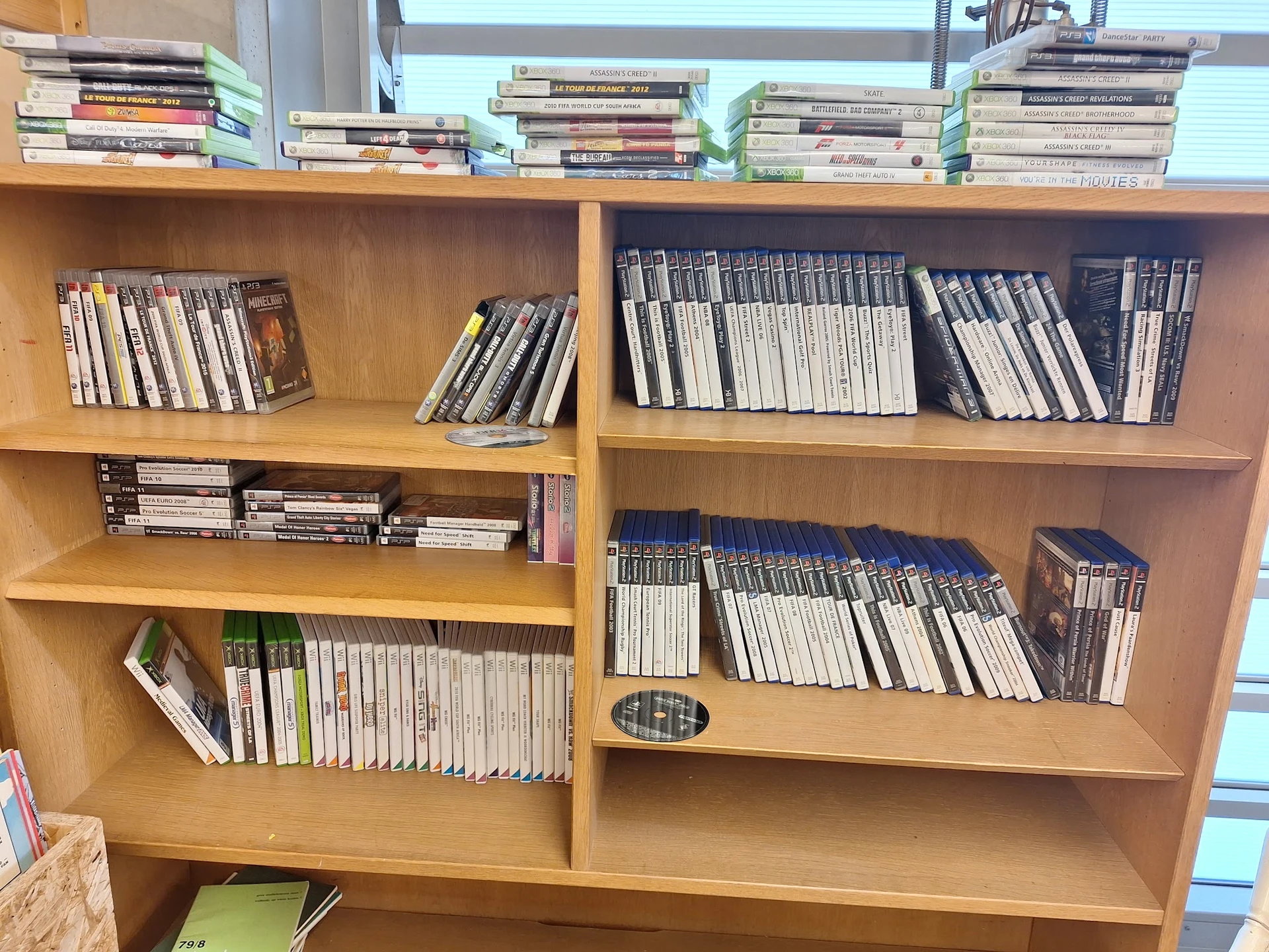Houten boekenkast met meerdere schappen vol dvd's en cd's netjes uitgestald