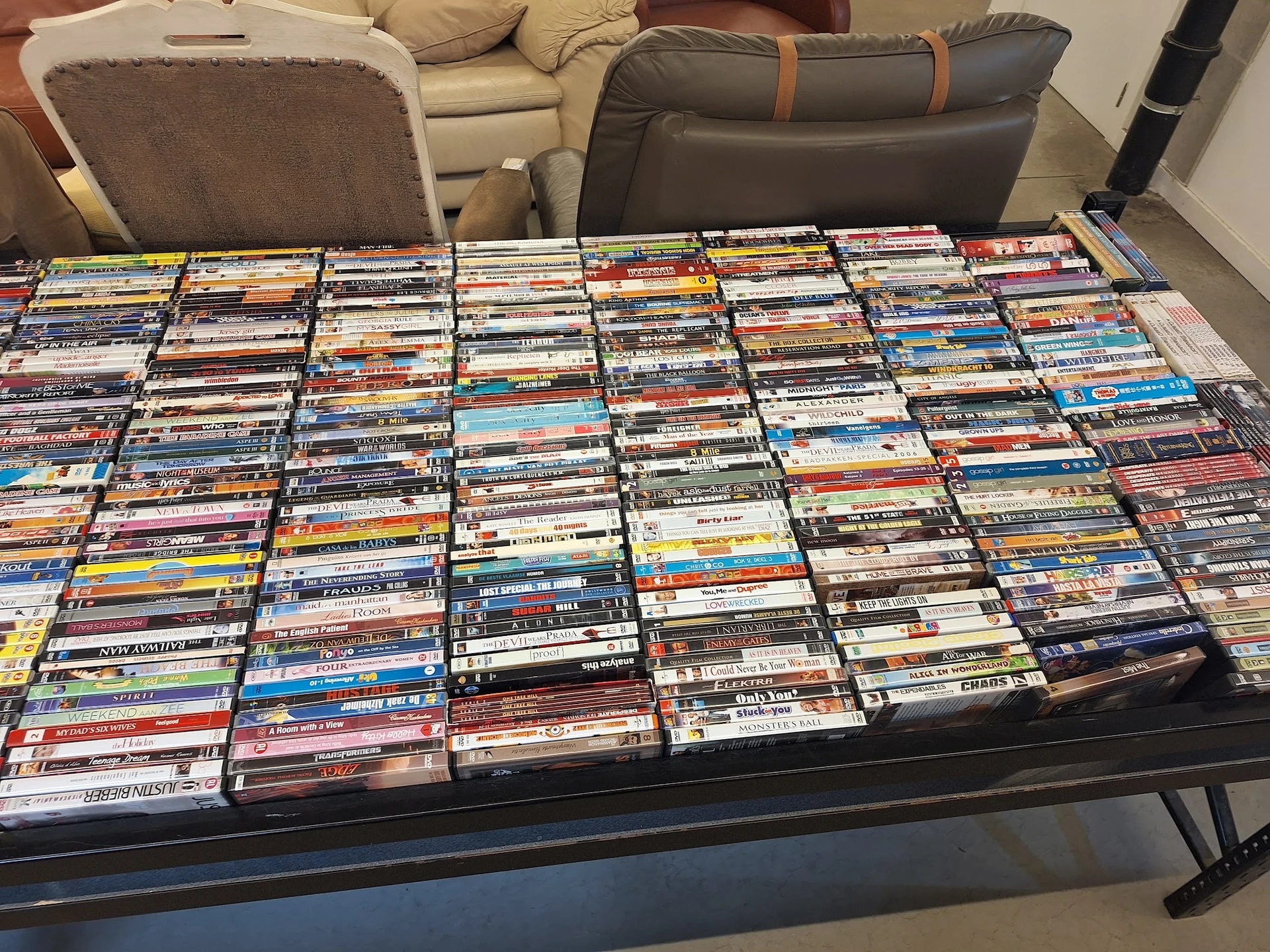 Grote collectie dvd's en blu-rays op een tafel uitgestald in rijen