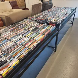 Lange tafel vol met tweedehands dvd's en blu-rays uitgestald op een winkelvloer