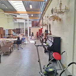 Ruim winkelpand met meubels, lampen en huishoudartikelen uitgestald, skylight in plafond