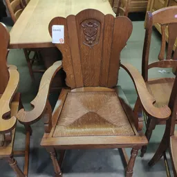 Houten stoel met hoge rugleuning en gevlochten zitting, voorkant gefotografeerd