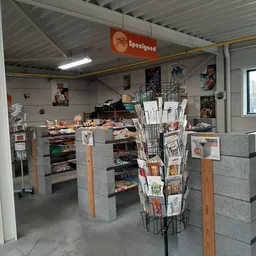 Winkelvloer met stellingen, display met kranten/tijdschriften en Speelgoed-bord aan het plafond