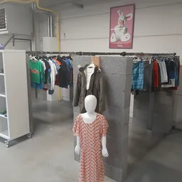 Tweedehands kleding op hangers en mannequins in de winkel