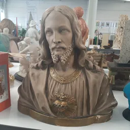 Bronzen buste van een man met lang haar en baard, dragende een gewad met hartmotief en ketting
