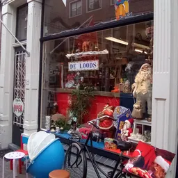 Winkelruit met kerststukken, beelden en decoraties, winkelname 'DE LOODS' zichtbaar