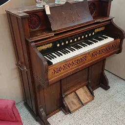 Antieke houten orgel met zwarte toetsen en gouden ornamentale details