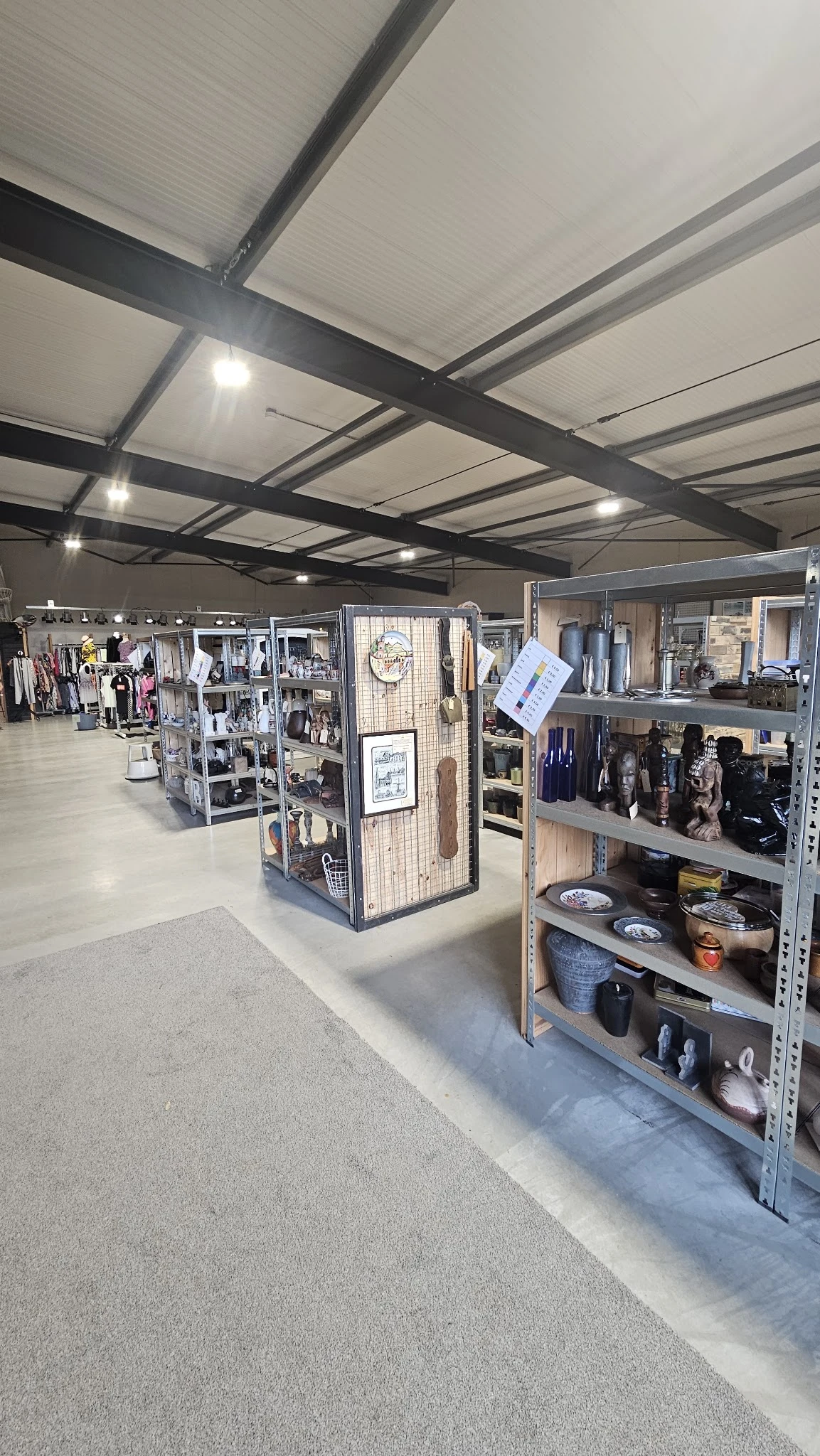 Overzicht van de winkelvloer met verschillende stellingen enDisplayBoxen met tweedehands artikelen