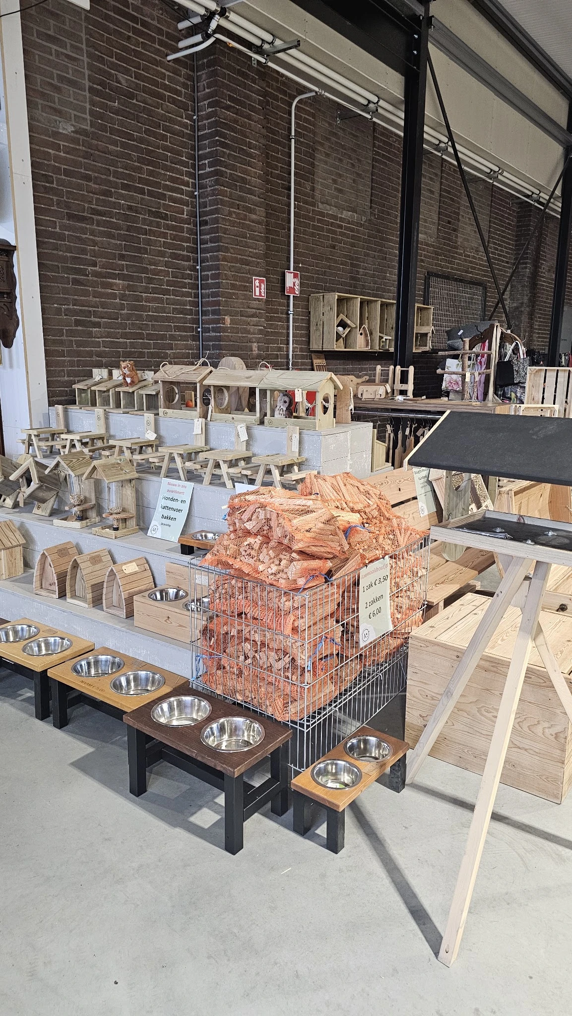 Winkelvloer van kringloopwinkel met houten speelgoed, huishoudelijke artikelen en dierenbehoefte in kratten
