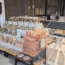 Winkelvloer van kringloopwinkel met houten speelgoed, huishoudelijke artikelen en dierenbehoefte in kratten