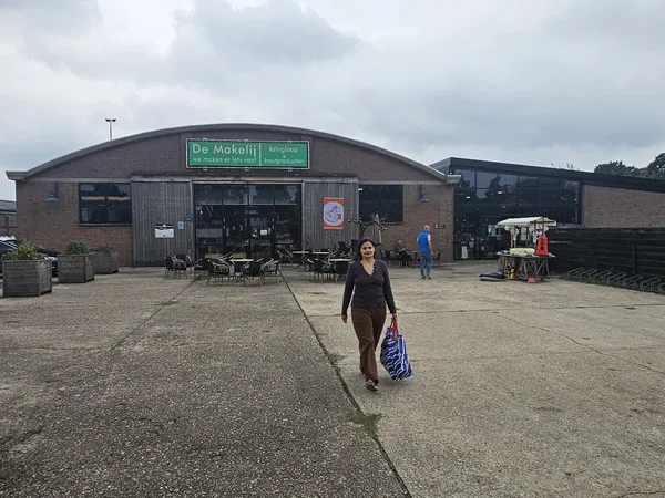 Voorkant van kringloopwinkel De Makelij, bakstenen gebouw met groene naambordje