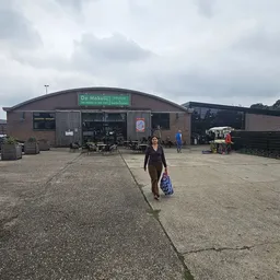 Voorkant van kringloopwinkel De Makelij, bakstenen gebouw met groene naambordje