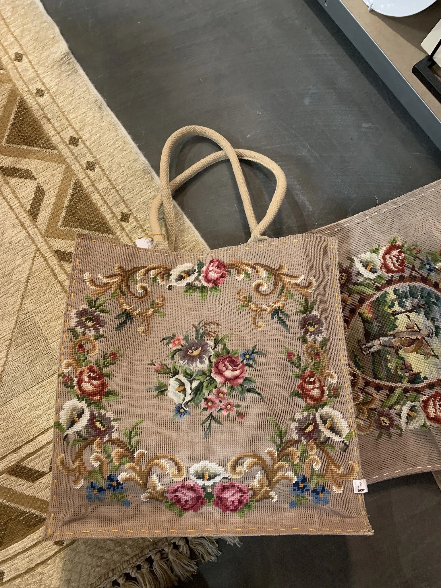 Close-up van een vintage jute tas met bloemenborduurwerk in roze en rode tinten
