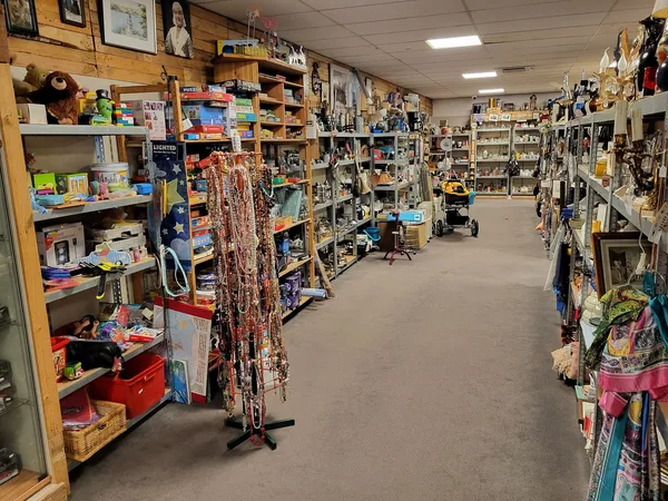 Winkelinterieur met houten stellingen, rekken en kasten vol met tweedehands spullen en merchandise