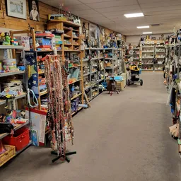 Winkelinterieur met houten stellingen, rekken en kasten vol met tweedehands spullen en merchandise