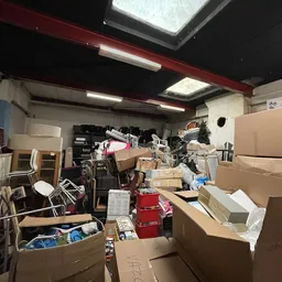 Voorraadartikelenopslagruimte met dozen, kartonnen dozen en diverse spullen op de grond