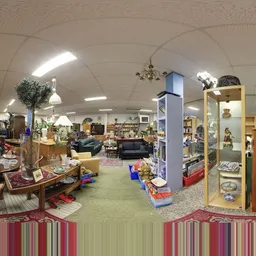 Winkelvloer van kringloopwinkel met meubels, boeken, decoratie en vitrines vol spullen