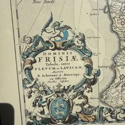 Historische kaart met decoratieve gravure van Frisia, met cherubs en ornamentale rand
